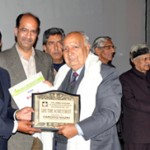 Minister for Tourism and Culture, Nawang Rigzin Zora presenting life time achievement award to Farooq Nazki at SKICC on Wednesday.