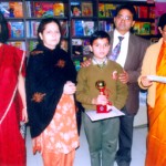 Winner of Inter School Debate Competition holding Trophy and Certificate while posing for a photograph alongwith dignitaries.