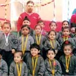 Children with medals posing for a group photograph during Annual Sports Day organized by Apple Kids on Monday.