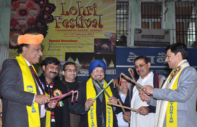 Divisional Commissioner Pardeep Gupta alongwith others playing dandia at Lohri Festival on Friday.
