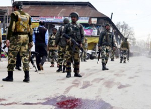 Paramilitary jawans inspect the spot where militants opened fire on police patrolling party in Sopore on Sunday