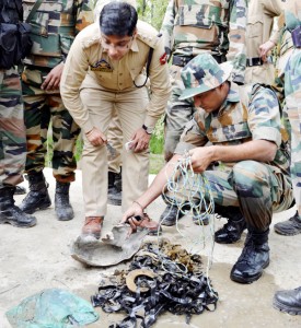 Army and police display pieces of an explosive device, which was found under a culvert on Srinagar-Baramulla road on Tuesday. —Excelsior/Amin War