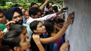 Admission seekers searching their name in cut-off merit list displayed by city colleges on Saturday. -Excelsior/Rakesh