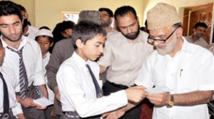 Minister for Panchayati Raj, Ali Mohd Sagar presenting cheque to student at Srinagar on Thursday.