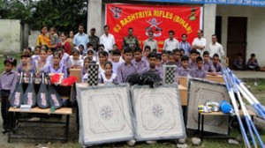 Students posing alongwith Army officers and officials after receiving sports gear, books and furniture for their schools.