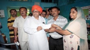 MLA Ashok Khajuria handing over a cheque to cancer patient family at Jammu on Saturday.