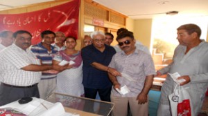 MLC Vijay Bakaya distributing cheques among sick Kashmiri migrants for medication at Jammu.