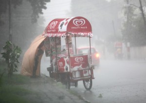 An ice cream seller takes cover from heavy rains in Jammu on Friday. —Excelsior/Rakesh