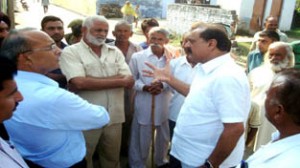 Former Minister S S Slathia interacting with border residents in Ramgarh on Wednesday.