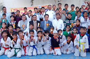 Young Taekwondo players posing for a photograph alongwith R S Chib, former Minister in Jammu on Wednesday.