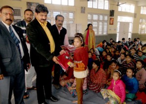 Chairman Jammu Citizen Cooperative Bank and other dignitaries distributing sweaters among children at Bal Niketan, Ved Mandir on Wednesday.
