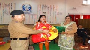 IG BSF, S S Tomar and president BSF WWA, Sweety Vinod presenting quilt to a needy BSF woman on Force's Raising Day in Jammu.