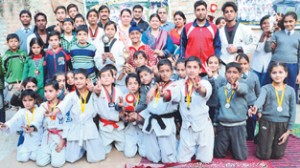 Taekwondo medal winners in various weight categories posing for a group photograph alongwith chief guest at Ankur Vidyalaya Public School in Jammu.