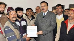 MoS Industries and Commerce, Sajjad Ahmad Kichloo distributing ex-gratia cheque on Tuesday.
