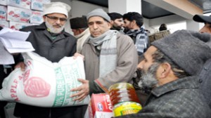 Minister for Rural Development Ali Mohd Sagar distributing relief to a fire victim at Srinagar on Friday.