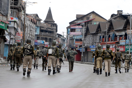 Paramilitary personnel patrolling a deserted street at Lal Chowk in Srinagar on Sunday. -Excelsior/Amin War