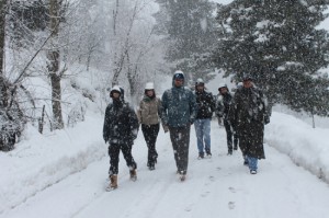 Tourists walk snow-covered area near famous Mughal Road connecting Poonch and Shopian on Monday. 	—Excelsior/Younis Khaliq
