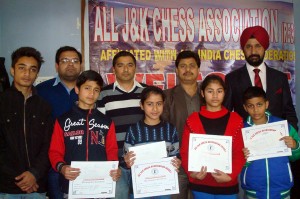 Winners of Under-19 Chess Tournament holding certificates while posing for a group photograph alongwith office bearers of the Association.