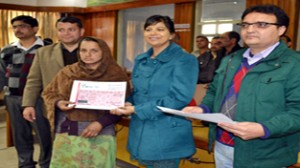 DDC Yasha Mudgal handing over relief cheque to a beneficiary at Udhampur on Saturday.