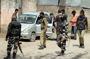 Security personnel inspecting the recovered vehicle at Ratnipora area of Pulwama district on Friday. -Excelsior/Younis Khaliq