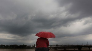 A man walks with an umbrella as clouds hover over the sky in Jammu on Friday.          —Excelsior/Rakesh