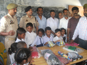Kids posing for a photograph while receiving sports kits.
