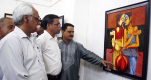 Renowned artist, Subhash Anand showcasing one of his paintings to the visitors during a painting exhibition at Amar Mahal Museum.
