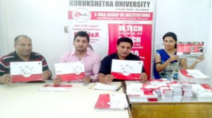 Executives of E-max Group of Institutions displaying brochures at newly inaugurated office in Jammu.