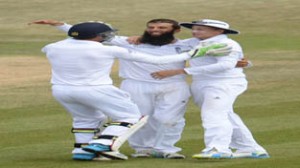 Moeen Ali is congratulated by team-mates Jos Buttler and Joe Root after dismissing India's Pankaj Singh.(UNI)