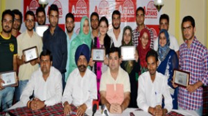 Meritorious J&K students of Aryans Group of Colleges posing alongwith dignitaries during a felicitation function in Srinagar. 