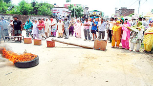 People protesting on Vijaypur-Ramgarh road against power crisis. -Excelsior/Gautam