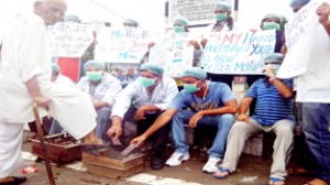 Dental surgeons polishing shoes to lodge their protest against Government at Jammu on Thursday.