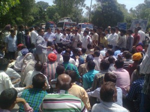 PHE daily rated workers sitting on dharna on Jammu-Poonch road at Sunderbani on Friday. 