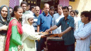 Advocate Maheshwar Singh Manhas, general secretary Pradesh Congress Committee distributing carry bags of clothes among the participants on Sunday.