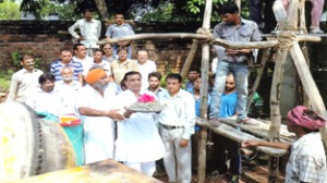 Advocate Maheshwar Singh Manhas, general secretary, Congress Committee inaugurating the laying of concrete slab of waiting hall and bathing ghat at Paloura on Monday.