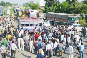 Truckers union members blocking National Highway at Kathua against killing of Excise Guard by rival faction of union.—Excelsior/Madan