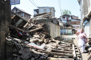 A woman showing her destroyed residential house by floods at Aabi Guzar residential area near Lal Chowk in Srinagar on Tuesday. — Excelsior/Amin War