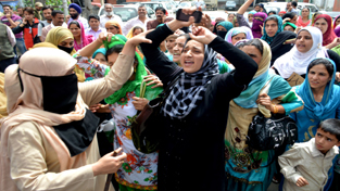 Police taking into custody Anganwadi workers during a protest in Srinagar on Monday. - Excelsior/Amin War
