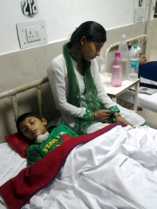 Shell shocked Neha looking after her injured brother in Government Medical College Hospital on Monday. —Excelsior/Rakesh