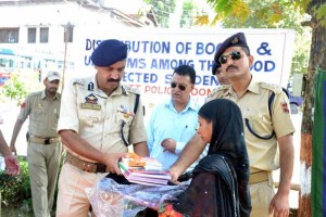 SSP Poonch, Shamsheer Hussain, giving books to a flood affected student at DPL Poonch.