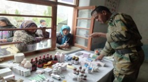 Army officer giving medicines to patients prescribed by doctors during medical camp.