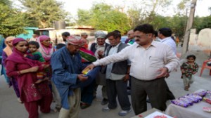JMC Commissioner Kiran Wattal distributing eatables among people at Jammu on Wednesday. 