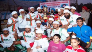 Jubliant winners posing for a photograph while receiving trophy.