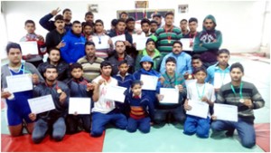 Winners of Wrestling Championship displaying certificates while posing for a group photograph.