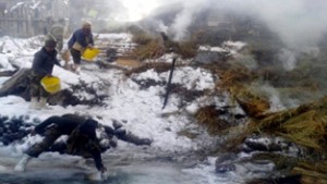 Army and people dousing  fire is a house at Gurez.