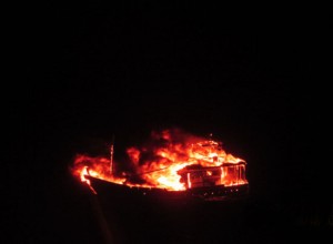A suspect fishing vessel set afire by its four member crew off Porbandar coast on Friday. (UNI)