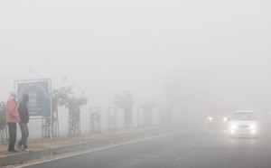 A car with headlights on moving through blanket of thick fog in the outskirts of Jammu on Sunday.—Excelsior/Rakesh
