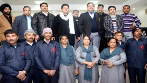 MLA Jammu East Rajesh Gupta, Commissioner, JMC Kiran Wattal and other officers of JMC posing with Safaikaracharis after distributing uniforms among them on Tuesday.