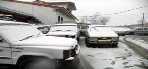 Vehicles laden with snow at a taxi stand in Srinagar after a fresh snowfall on Monday. (UNI)