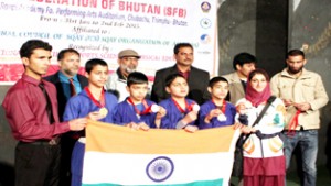 Victorious Sqay players of Jammu and Kashmir holding Indian National Flag while posing for a group photograph.
